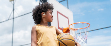Kids playing basketball safely with Shokz headphones