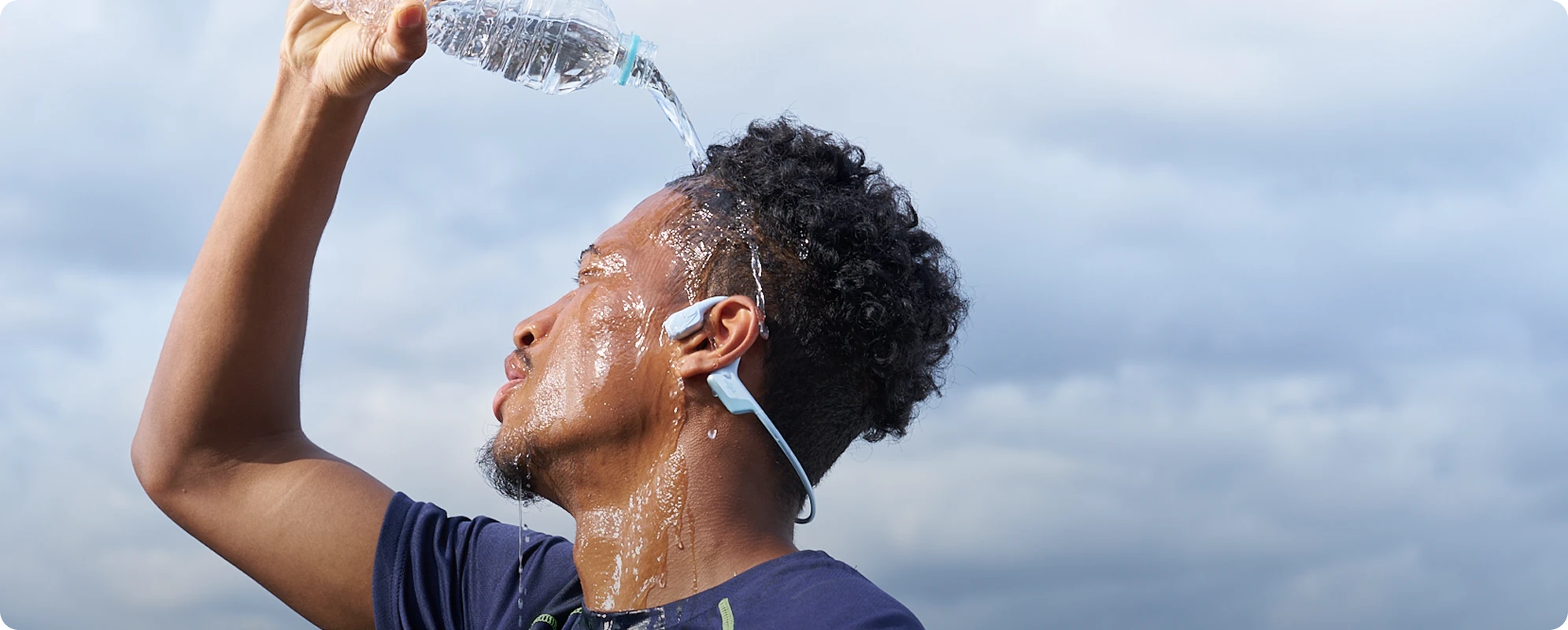 Person pouring water while wearing OpenRun Air 2